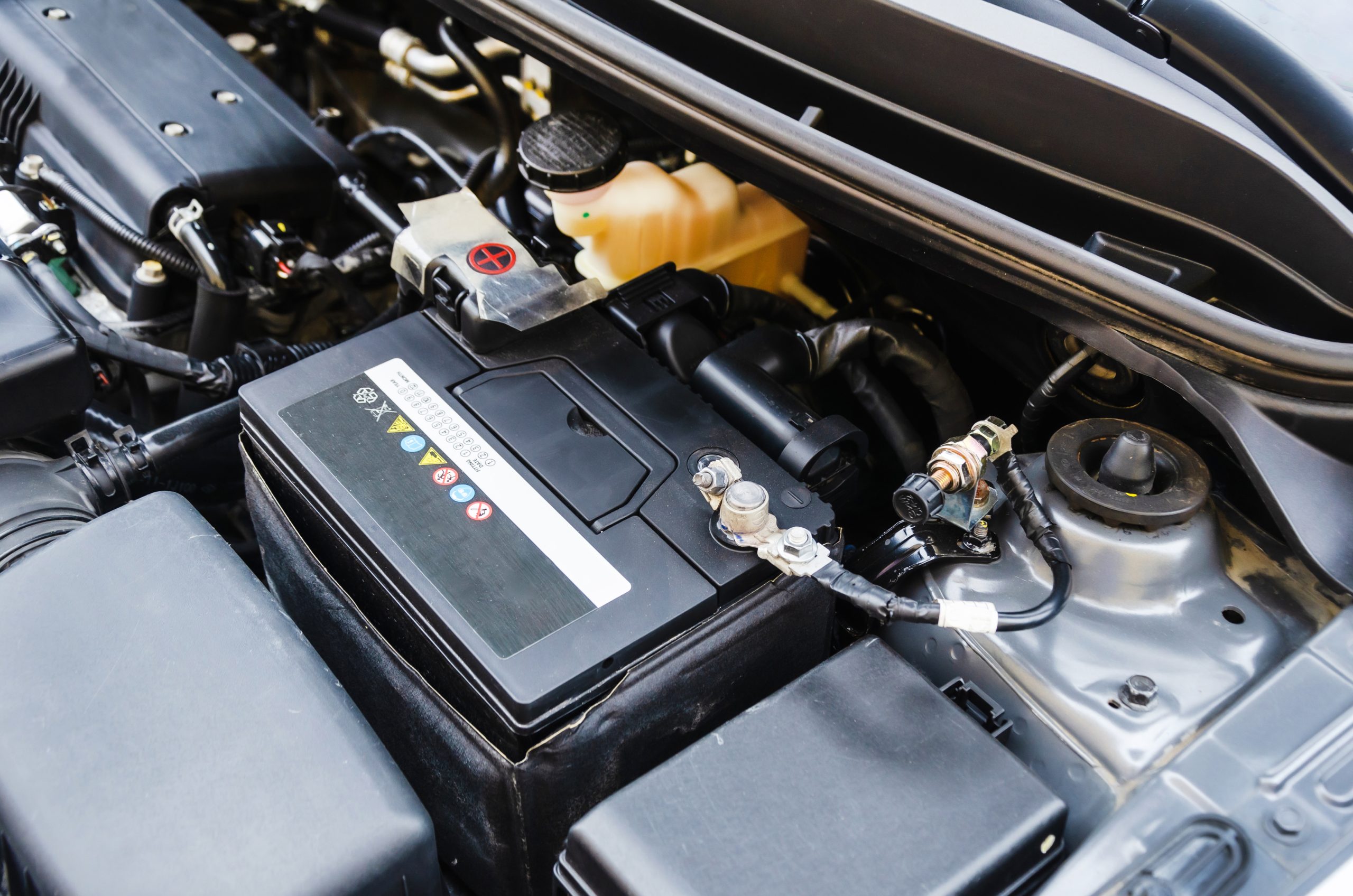 battery is under open hood of car. Terminal for disconnecting battery car before long-term parking Niskie ceny wysoka jakość